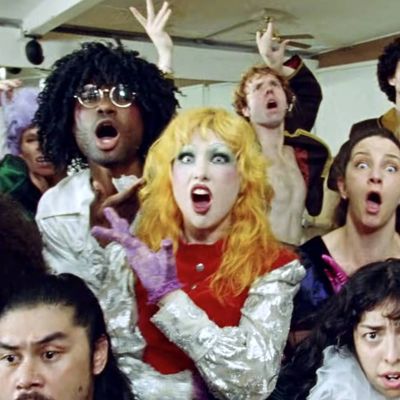 Screenshot aus dem Video Dance The Pain Away. Haute & Freddy umgeben von Tänzer*innen machen Grimassen und schauen dabei direkt in die Kamera.