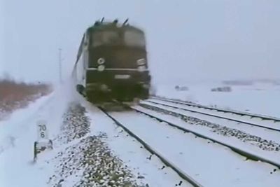Alte Diesellog im Winterwetter auf einem verschneitem Bahndamm.