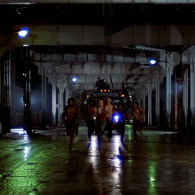 Blick vom Strand auf den Vergnügungspark in Coney Island. Es sind mehrere Fahrgeschäfte und Buden zu sehen, davor der Sand des Strandes, der bis an den Park heranreicht.