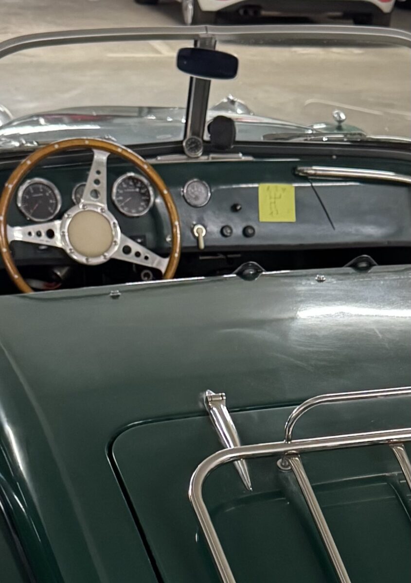 Oldtimer Cabriolet in Tannengrün, Ausschnitt des Cockpit, daran klebt ein Post-it mit dem Schaltbild des Wagens.