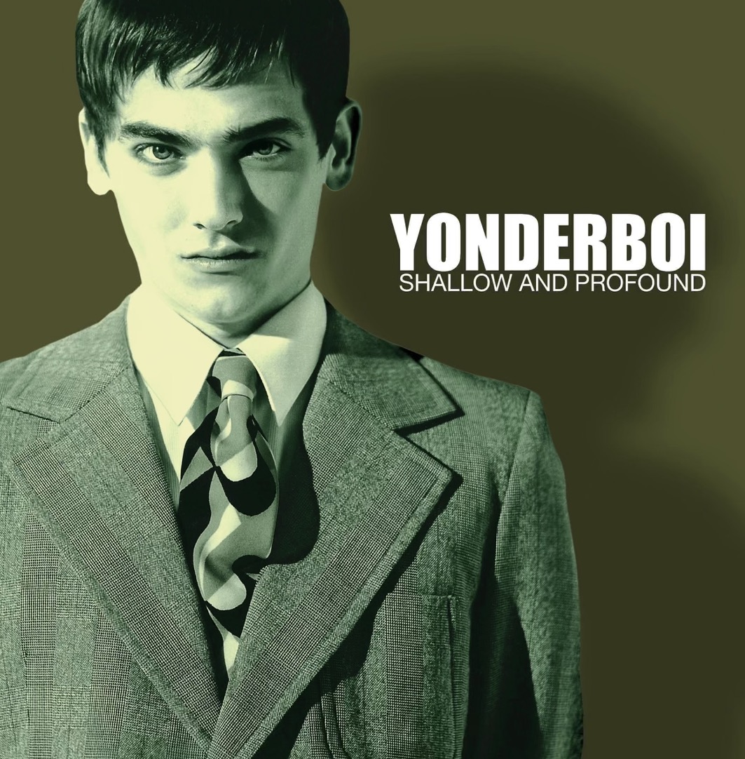 Albumcover: Yonderboi „Shallow and Profound“. Ein junger Mann im 60er-Jahre Anzug in der Halbtotalen schaut uns an.