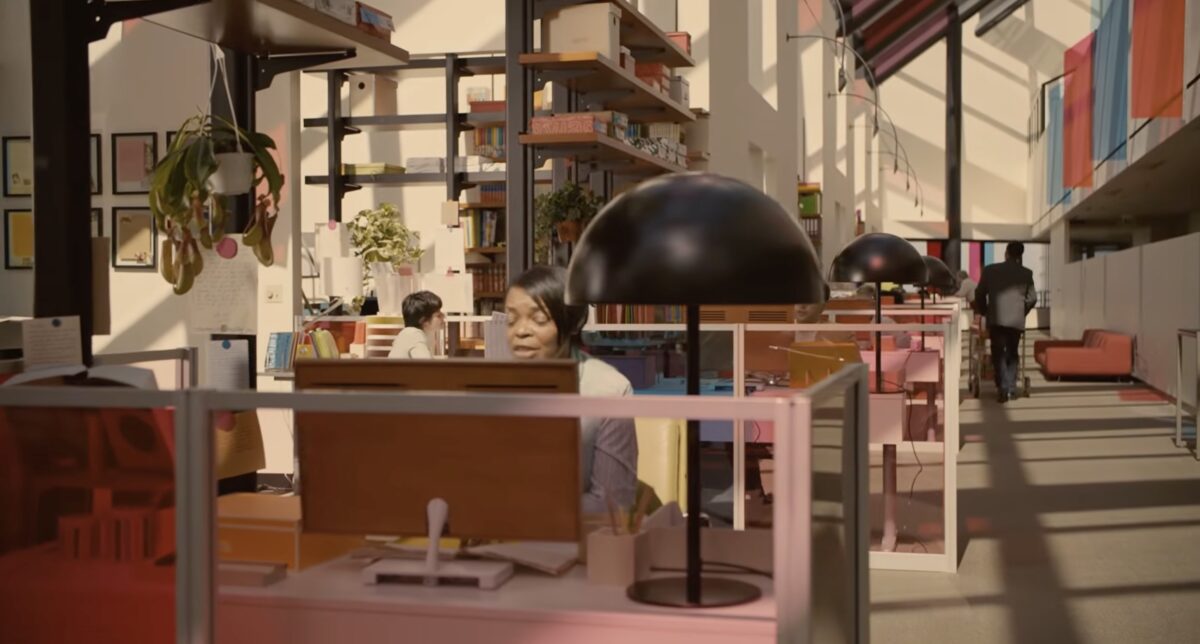 Filmstill aus Her: ein lichtdurchflutetes Büro mit verglasten Cubicles, bonbonfarbenden Flächen und Menschen, die allesamt mit ihrem Computer sprechen.