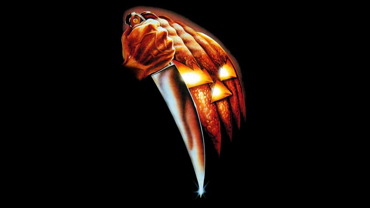 Ausschnitt Filmposter: Im Vordergrund eine Hand, die ein großes Schlachtermesser krampfhaft umklammert hält, dahinter ein stilisierter Halloween-Kürbis, vor schwarzem Hintergrund.