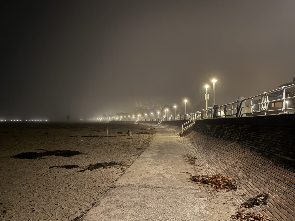 Strandpromenade nachts im Nebel